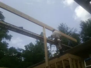 Carpenter setting a ridge beam over a new addition frame — Ice Dam Removal by Roofing Brothers in Red Bluff