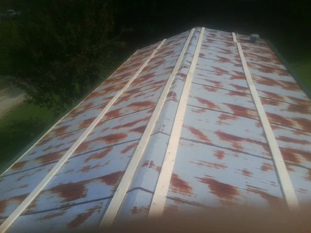 Rusted metal roof panels with new wood purlins before replacement — Storm Damage Roof Repair in Red Bluff by Roofing Brothers