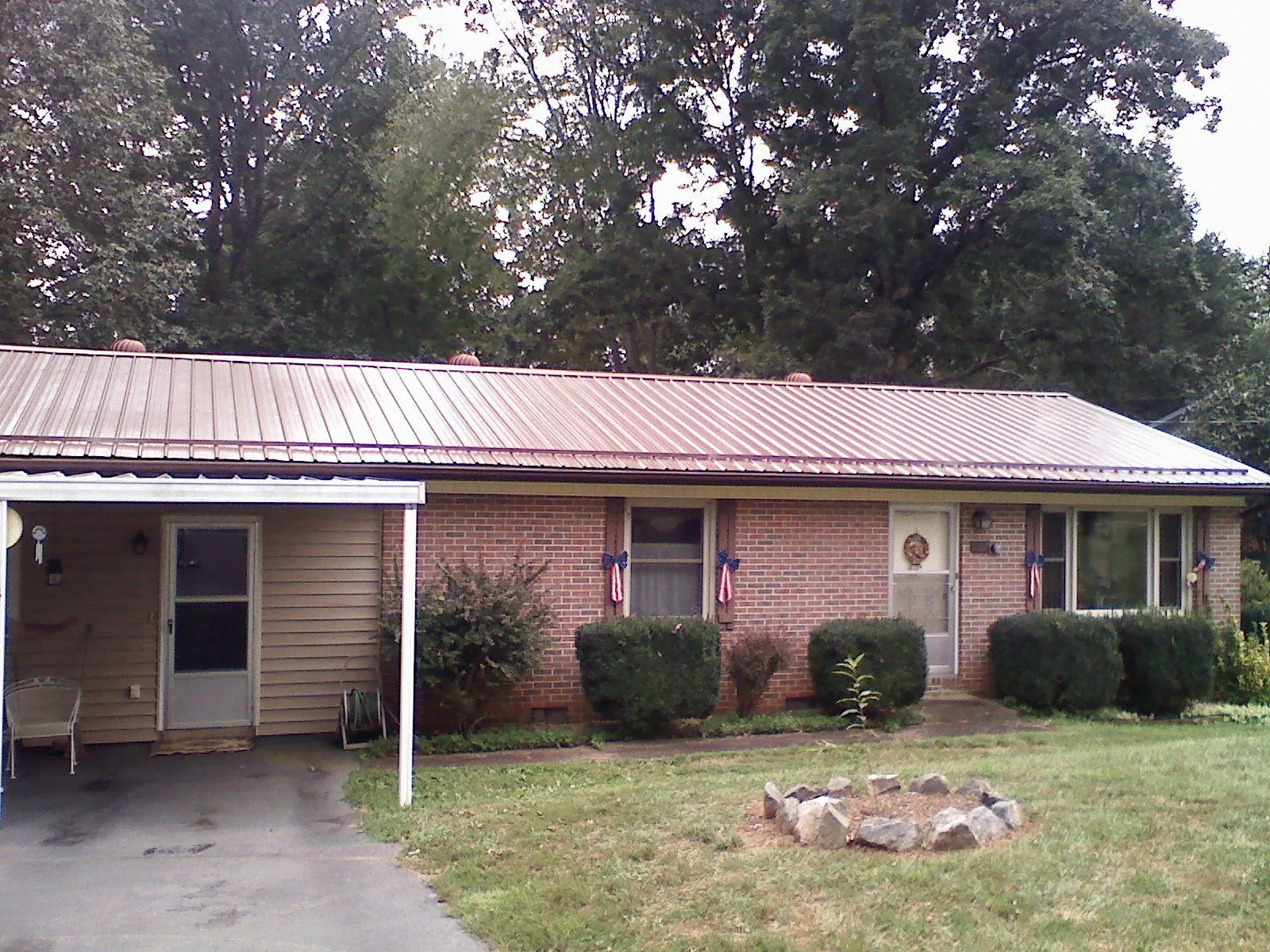 Bronze metal roof and carport on a brick ranch home — Roof Repair work by our crew in Red Bluff